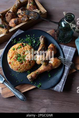 Riso Djuvec o riso serbo con bastoncini di pollo al forno su un piatto Foto Stock