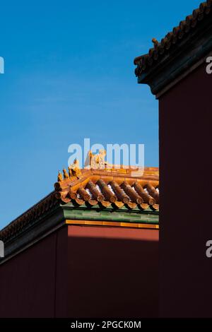 Uno scatto verticale dei tetti delle torrette della Città Proibita di Pechino contro un cielo blu chiaro Foto Stock