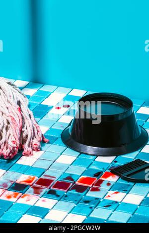 Tessere mosaico blu e bianche con macchie di sangue vicino ai capelli neri pennello colorante e ciotola contro la parete blu Foto Stock