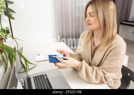 ritratto di bella donna in possesso di modello di aereo e passaporto con biglietti Foto Stock