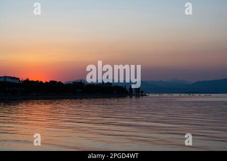 Il sole si adagia sul Lago di Garda nella graziosa cittadina di Peschiera del Garda Foto Stock