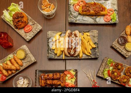 Set di ricette per cucina cubana, fast food e cucina venezuelana, un hot dog con salse, alcuni teques, un tamale, pollo in pastella e salse Foto Stock