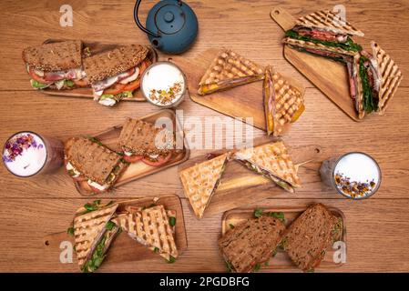 Set di snack, panini e bevande su un tavolo di legno. Foto Stock
