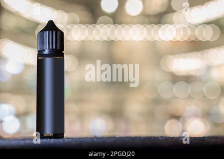 Barattolo nero di gorilla bottiglia per tabacco liquidi sigarette elettroniche. Spazio per il testo, etichetta vuota. Sfondo sfocato chiaro Foto Stock