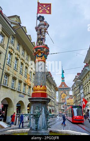 BERNA, SVIZZERA - 31 MARZO 2022: La fontana medievale Schutzenbrunnen si trova al centro della via Marktgasse, il 31 marzo a Berna, in Svizzera Foto Stock