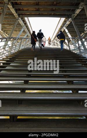 Persone (irriconoscibili; vista sul retro) sul ponte pedonale Solferino sulla Senna vicino al Museo di Orsey. Parigi, Francia. Romanticismo urbano. Foto Stock