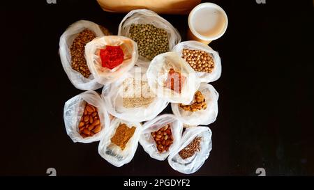 Una varietà di prodotti alimentari in sacchetti di carta aperti, comprese spezie e condimenti Foto Stock