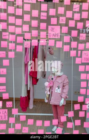 Vetrina di un negozio di abbigliamento coperto di post-it rosa, formando una finestra circolare in cui sono esposti i vestiti rosa. Bruxelles. Foto Stock