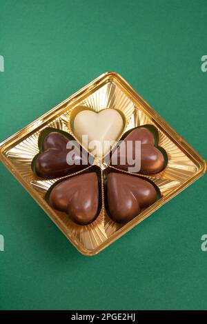 Foto ravvicinata di cioccolatini di diversi gusti su sfondo verde Foto Stock