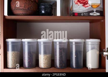 Organizzazione di stoccaggio in cucina, vasetti riutilizzabili trasparenti per cereali, caffè, zucchero e pasta. Foto Stock