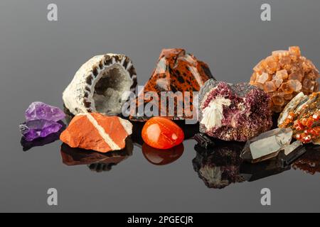 Foto ravvicinata del Gruppo delle pietre e dei minerali, tra cui il gelsomino rosso, l'aragonite Sputnik, i cristalli di Erythrite, l'Obsidiana di Mogano e l'Agata Geode su R Foto Stock