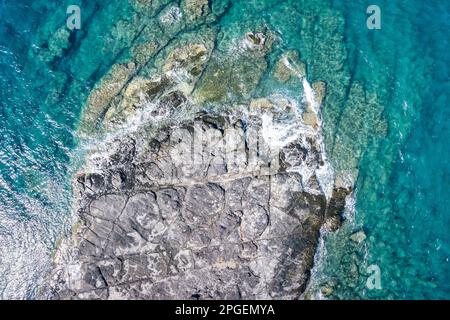 Sopra il mare tropicale e l'onda si schiantano sulla roccia della barriera corallina in estate Foto Stock