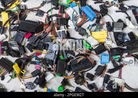 Fili elettrici multicolore con connettori per auto su sfondo bianco isolato durante la riparazione della rete da parte di un tecnico o meccanico in assistenza o in riparazione Foto Stock