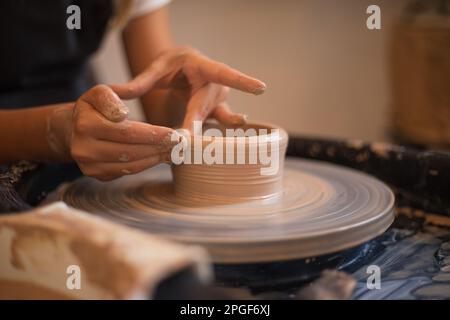 Le mani di una bambina nel processo di scolpire una tazza con ce Foto Stock