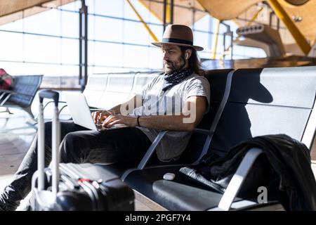 il ragazzo nel cappello all'aeroporto Foto Stock