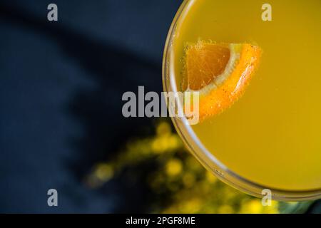 Cocktail Mimosa in vetro su tavolo in pietra nera Foto Stock