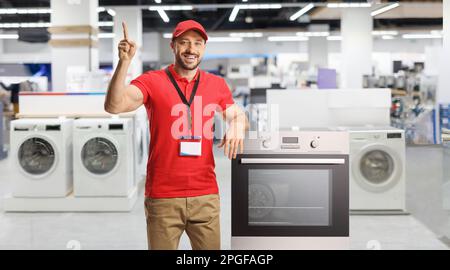 Venditore con elettrodomestici sorridenti e puntati all'interno di un negozio Foto Stock