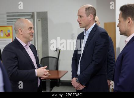 Il Principe del Galles parla con Kevin J. Allen, rappresentante dell'Alto Commissariato delle Nazioni Unite per i rifugiati in Polonia (a sinistra) durante una visita in un centro di alloggio a Varsavia, Polonia, Che ospita circa 300 donne e bambini ucraini che sono arrivati nel paese più recentemente e sono attualmente meno integrati nelle comunità polacche. Il centro è gestito dalla Città di Varsavia ed è aperto subito dopo l'inizio della guerra in Ucraina. Data immagine: Mercoledì 22 marzo 2023. Foto Stock