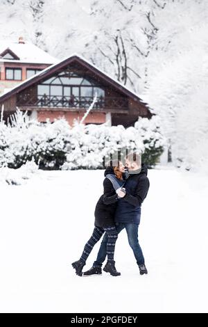 Coppia che ama ballare nel parco innevato Foto Stock