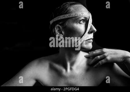 Ritratto di una donna forte che contempla come misura Foto Stock