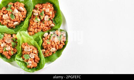 Tazzine di lattuga di carne tritata in stile thailandese su sfondo bianco con spazio copia. Vista dall'alto, piatto Foto Stock