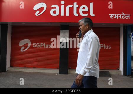 Mumbai, India. 22nd Mar, 2023. Un uomo che comunica con un telefono cellulare passa davanti al negozio Airtel di Mumbai. Airtel offre dati illimitati ai suoi 5G clienti in 26 città. Esso coprirà l'intero paese, gli utenti rurali e urbani entro la fine di marzo 2024. (Foto di Ashish Vaishnav/SOPA Images/Sipa USA) Credit: Sipa USA/Alamy Live News Foto Stock