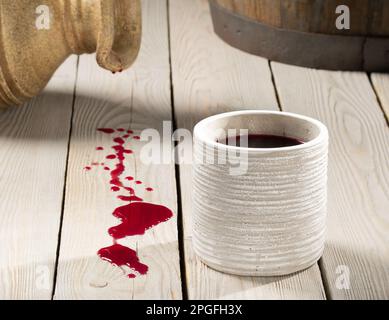 Caraffa di argilla per vino, barile di vino e bicchiere di argilla di vino rosso su un tavolo di legno Foto Stock