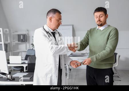 Paziente con brigata e medico che agita le mani in clinica Foto Stock