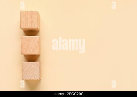 Cubi di legno con segni di spunta su sfondo beige Foto Stock