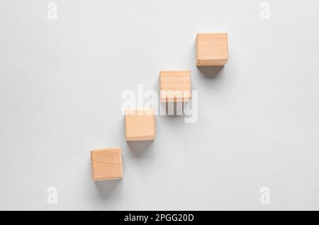 Cubi di legno con segni di spunta su sfondo grigio Foto Stock