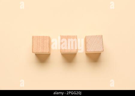 Cubi di legno con segni di spunta su sfondo beige Foto Stock