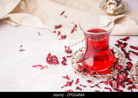 Bicchiere di tè di ibisco turco su tavolo bianco Foto Stock