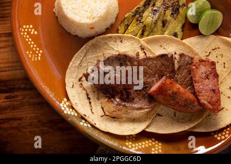 Arrosto di tacos di carne con chorizo. Piatti molto popolari nel nord del Messico, chiamato anche Carne Asada, Asado, Discada o Parrillada, è una tecnica di cottura in Foto Stock