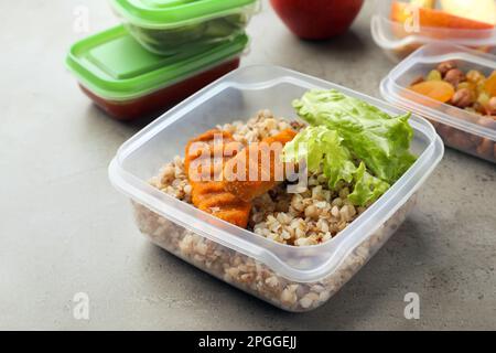 Set di contenitori in plastica con alimenti freschi su tavolo grigio chiaro Foto Stock