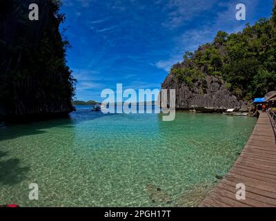 Una baia con rocce maestose a Coron, Palawan nelle Filippine che sono cresciute con arbusti e sorgono dall'acqua. Foto Stock