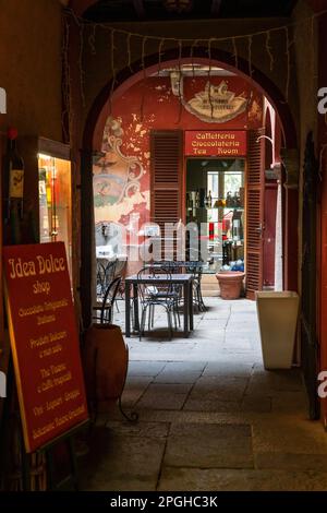 Orta San Giulio, Italia - 13 marzo, 2023: Ingresso cortile ad un elegante e squallido caffè di strada e panetteria nel centro del paese di Orta San Giulio Foto Stock