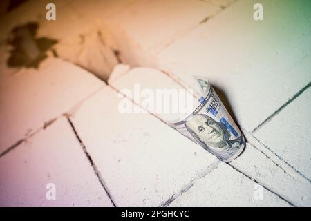 Crepe nella parete di mattoni di calcestruzzo aerato, cento dollari inseriti nella parete in un cantiere. Il processo di taglio di una porta in un Foto Stock