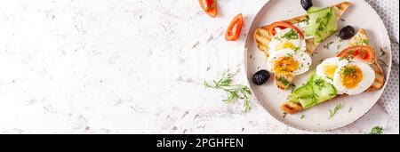 Colazione sana. Toast con formaggio feta e uova. Cibo sano equilibrato. Vista dall'alto, banner Foto Stock