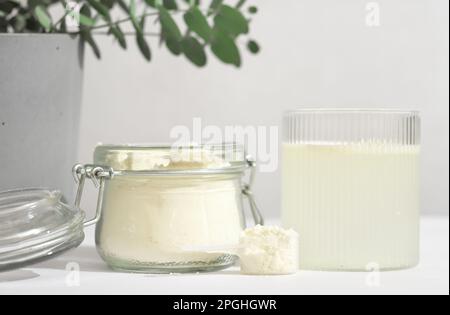 cucchiaio di collagene di pesce. peptidi del collagene in vasetto di vetro. polvere per la miscelazione della bevanda. Concetto di supplemento sanitario. collagene per pelle e articolazioni e vetro ad acqua Foto Stock