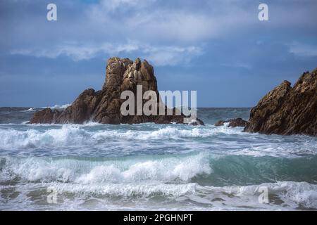 Mare mosso e onde forti su una costa rocciosa selvaggia Foto Stock