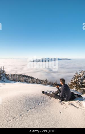 L'alpinista riposa su una radura che domina i monti Beskydy circostanti nella regione moravo-silesiana dopo aver scalato Lysa Hora. Pausa piacevole Foto Stock