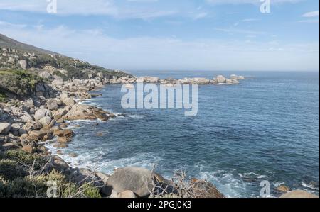 Paesaggio con scogliere e massi sulla riva dell'oceano vicino a Oudekraal, girato nella luce estiva a Città del Capo, Capo Occidentale, Sud Africa Foto Stock