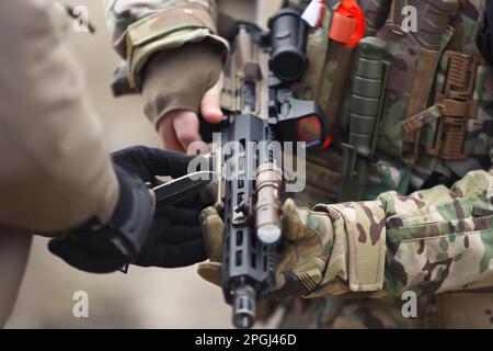 Soldati ucraini che sintonizzano fucile d'assalto sul campo di tiro. Uomini militari delle forze armate ucraine si allenano con armi americane moderne Foto Stock