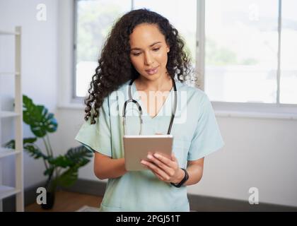 Ritratto di una giovane dottoressa biraciale, utilizzando una tavoletta digitale, eHealth Foto Stock