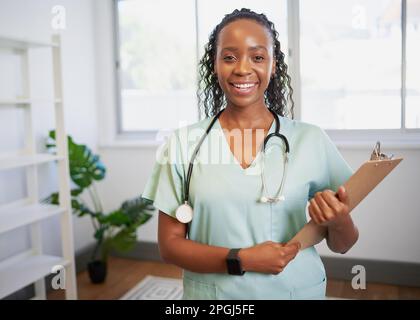 Ritratto di una giovane dottoressa nera, braccia piegate sorridendo in ufficio modeno Foto Stock
