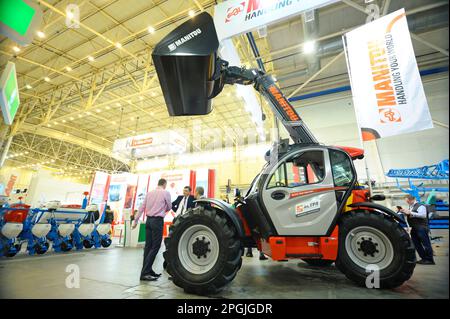 Nuovo modello di mini retroescavatore presentato su uno stand, persone che camminano intorno. Fiera AgroTrade Show-2019. Febbraio 19, 2019. Kyiv , Ucraina Foto Stock