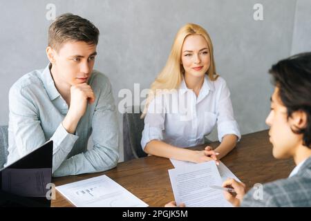 Vista posteriore dell'uomo d'affari conduce il coaching nella sala del consiglio di amministrazione durante la riunione dell'azienda. Fidarsi giovane uomo d'affari che si occupa della formazione del team aziendale al briefing. Foto Stock