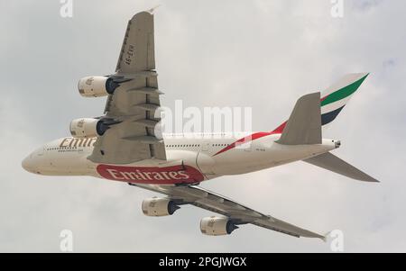 Un'immagine ad angolo basso di una compagnia aerea Airbus 380 di Emirates che sorvola l'aeroporto internazionale di Dubai Foto Stock