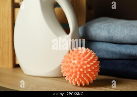 Asciugatore arancione palla e detergente su abiti puliti in lavanderia,  primo piano Foto stock - Alamy