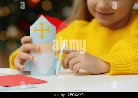 Ragazza carina con carta San Nicola giocattolo a casa, primo piano Foto Stock